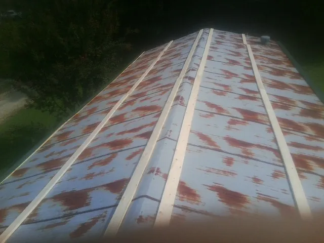 Rusted metal roof panels with new wood purlins before replacement — Storm Damage Roof Repair in Haynesville by Roofing Brothers