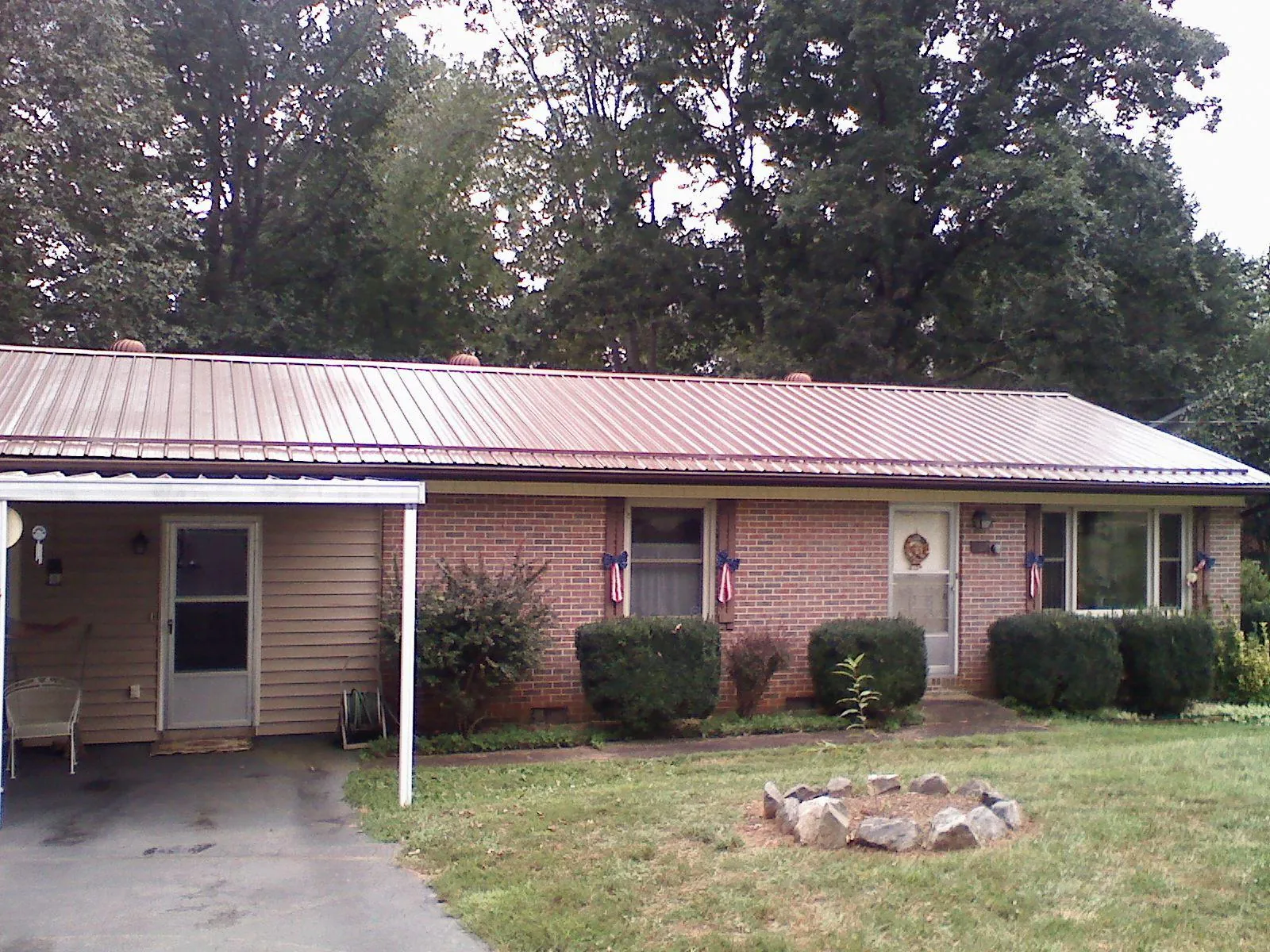 Bronze metal roof and carport on a brick ranch home — Roof Repair work by our crew in Haynesville
