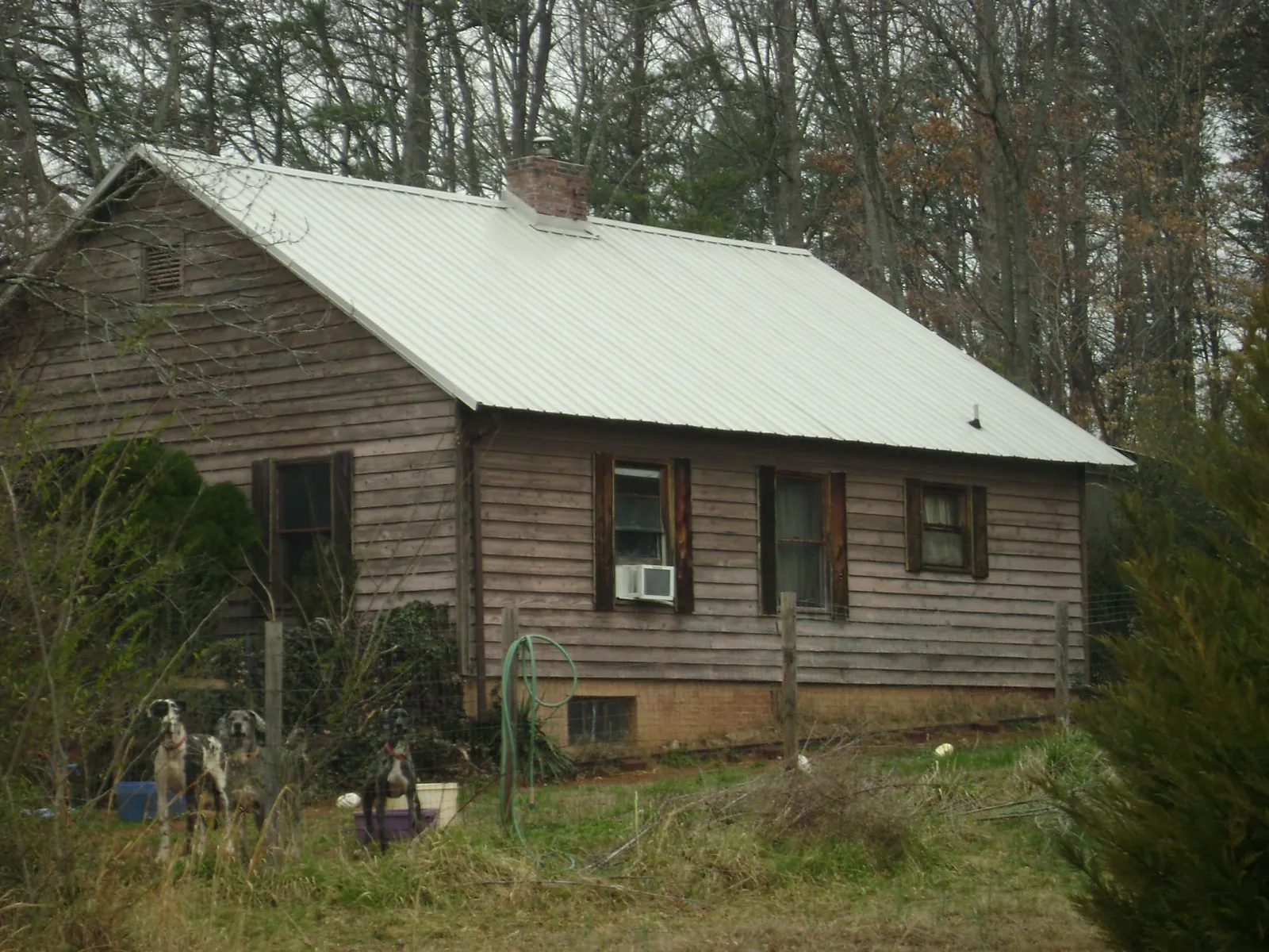 White metal roof on an old wood sided farmhouse, from a Metal Roof Installation job in Haynesville